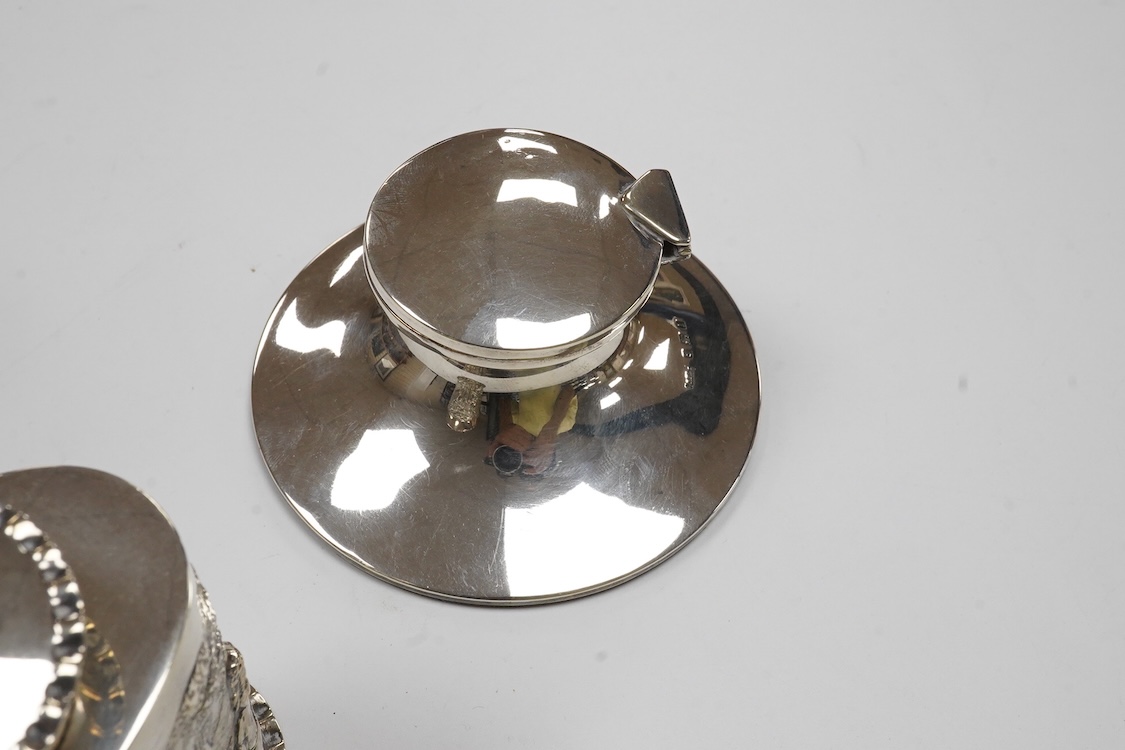 A late Victorian repousse silver oval tea caddy, by Nathan & Hayes, Chester, 1896, height 75mm, together with a George V silver mounted capstan inkwell.